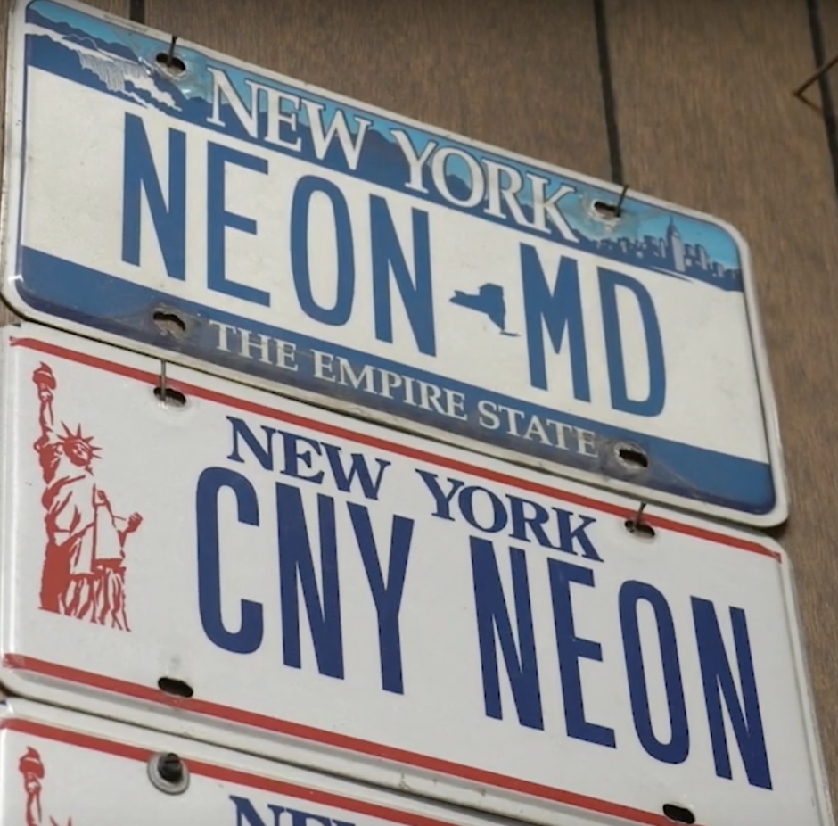 License plates on the wall of a neon shop